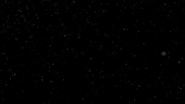 Glowing Particles in the Dark. Small white particles flow in the air on a black background to simulate snow, blizzard, or a microcosm of the Christmas magic. Filmed at a speed of 240fps