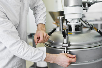 worker closes industrial mixer, food industry, conveyor line