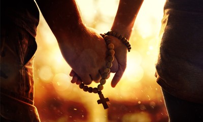 Couple praying together. Holding rosary in hand. © BillionPhotos.com