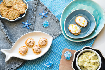 flat lay crispy toasts on several blue plates, with salmon saladcrispy toasts on several blue plates, with salmon salade, cream chees and butter 2e, cream cheese and butter 
