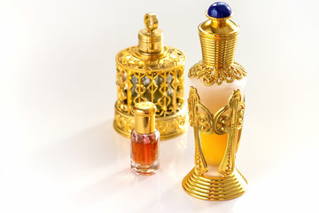 Traditional golden ornate flask of Arabian oud oil perfumes. Isolated white background. Copy space.
