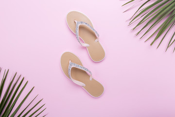 beautiful woman's beach flip-flops on the light pastel pinl background. beach summer concept and holiday concept, top view
