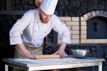 cook preparing pizza in a restaurant.