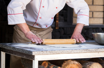 cook preparing pizza in a restaurant.