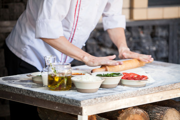 cook preparing pizza in a restaurant.