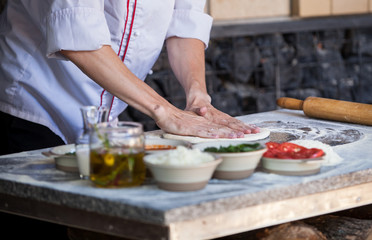 cook preparing pizza in a restaurant.