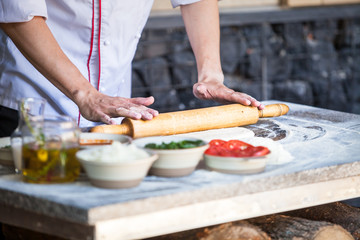 cook preparing pizza in a restaurant.