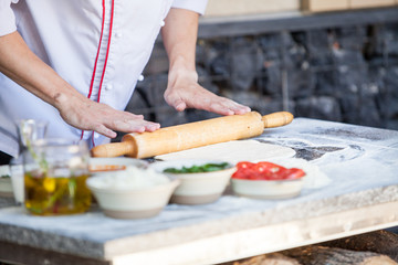 cook preparing pizza in a restaurant.
