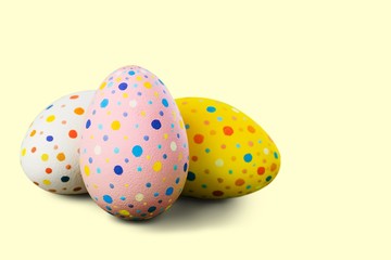 three Easter eggs on a pale yellow background