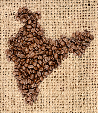 Whole bean coffee. The contour of the India is made of coffee beans on jute burlap