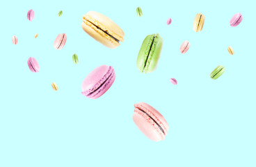 colorful macaroons flying in the air at soft blue background