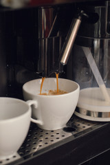 coffee maker pours coffee into the cup.