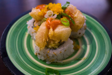 fried shrimp sushi roll on a green plate