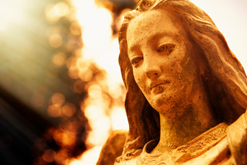 Antique statue of wonderful angel in the rays of the sun. Architecture, sculpture, religion, faith...
