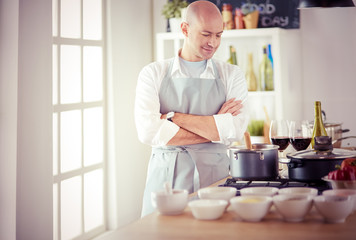 Handsome man is cooking on kitchen and smiling