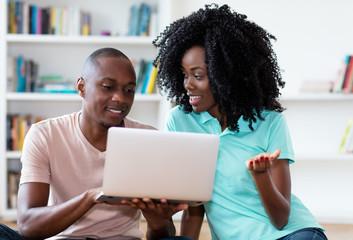 African american couple searching job online with computer
