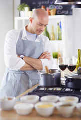 Handsome man is cooking on kitchen and smiling