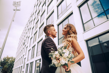 Couple in love on a walk in the city.The couple on the background of a modern building.Wedding photo