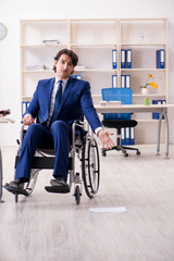 Young male employee in wheelchair working in the office 
