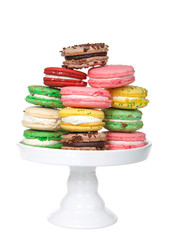 Macaron cookies in various spring colors stacked on a white pedestal isolated on white. Popular French treat.
