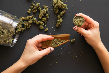 Woman preparing and rolling marijuana cannabis joint. Close up Woman rolling a marijuana joint....