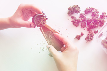 Woman preparing and rolling marijuana cannabis joint. Close up of marijuana blunt with grinder....