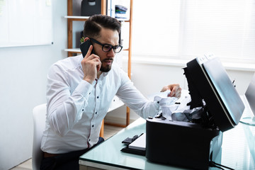 Businessman Removing Stuck Paper In The Printer