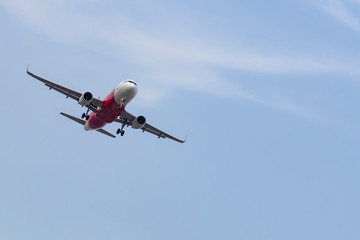 Commercial airplane flying with blue sky background.