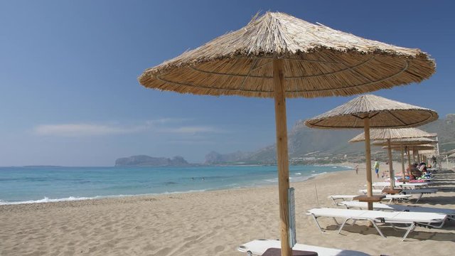 Umbrellas on the beach and emerald seas at Falassarna beach in Western Crete