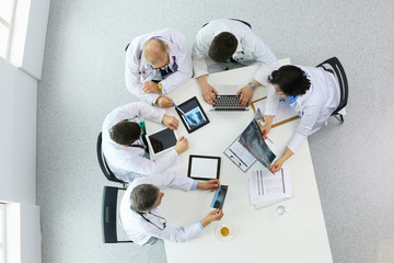 Medical team sitting and discussing at table, top view