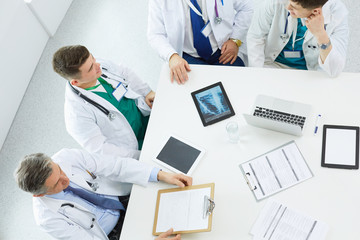 Obraz premium Medical team sitting and discussing at table, top view