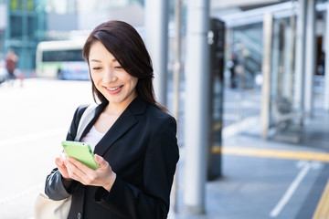 ビジネスウーマン　スマホ　駅