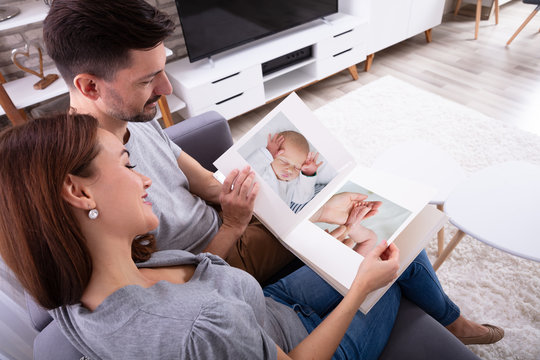 Couple Looking At Baby's Photo Album