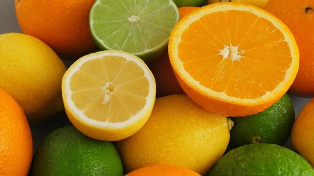 Half cut juicy lime on citrus fruit background, a lot of lemon, oranges and limes. Rotate