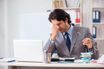 Naklejka premium Young handsome businessman in budget planning concept 