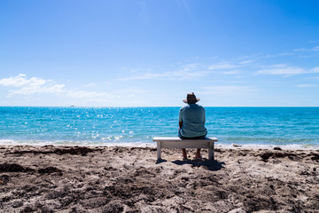 Man sitting on the bench at tropical beach.