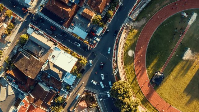 Timelapse Top View of Stadium Jogging Track Beside Busy Intersection Road in Indonesia