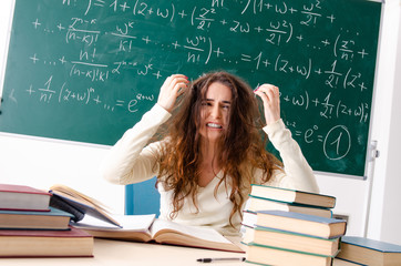 Young female math teacher in front of chalkboard  