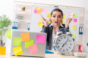 Young female employee in conflicting priorities concept 