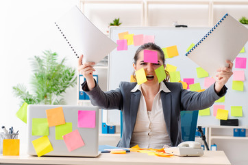 Young female employee in conflicting priorities concept 