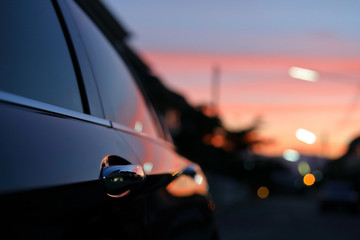 luxury vehicle black car with blur twilight dramatic sky, image selective focus on door handle