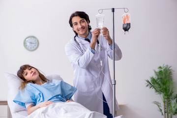 Male doctor visiting female patient in ward 