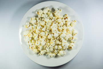 Popcorn in a plate on white background