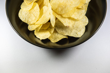 Potato chips in a plate on white background