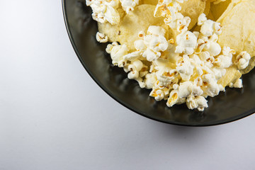 Potato chips and Popcorn in a plate on white background