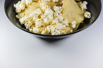Potato chips and Popcorn in a plate on white background