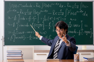 Young male math teacher in classroom 