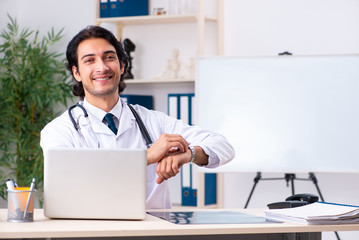 Young handsome doctor working in clinic 