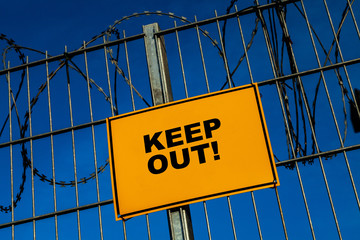 Keep out! Signpost on a barbed wire