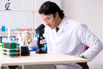 Young handsome chemist working in the lab 